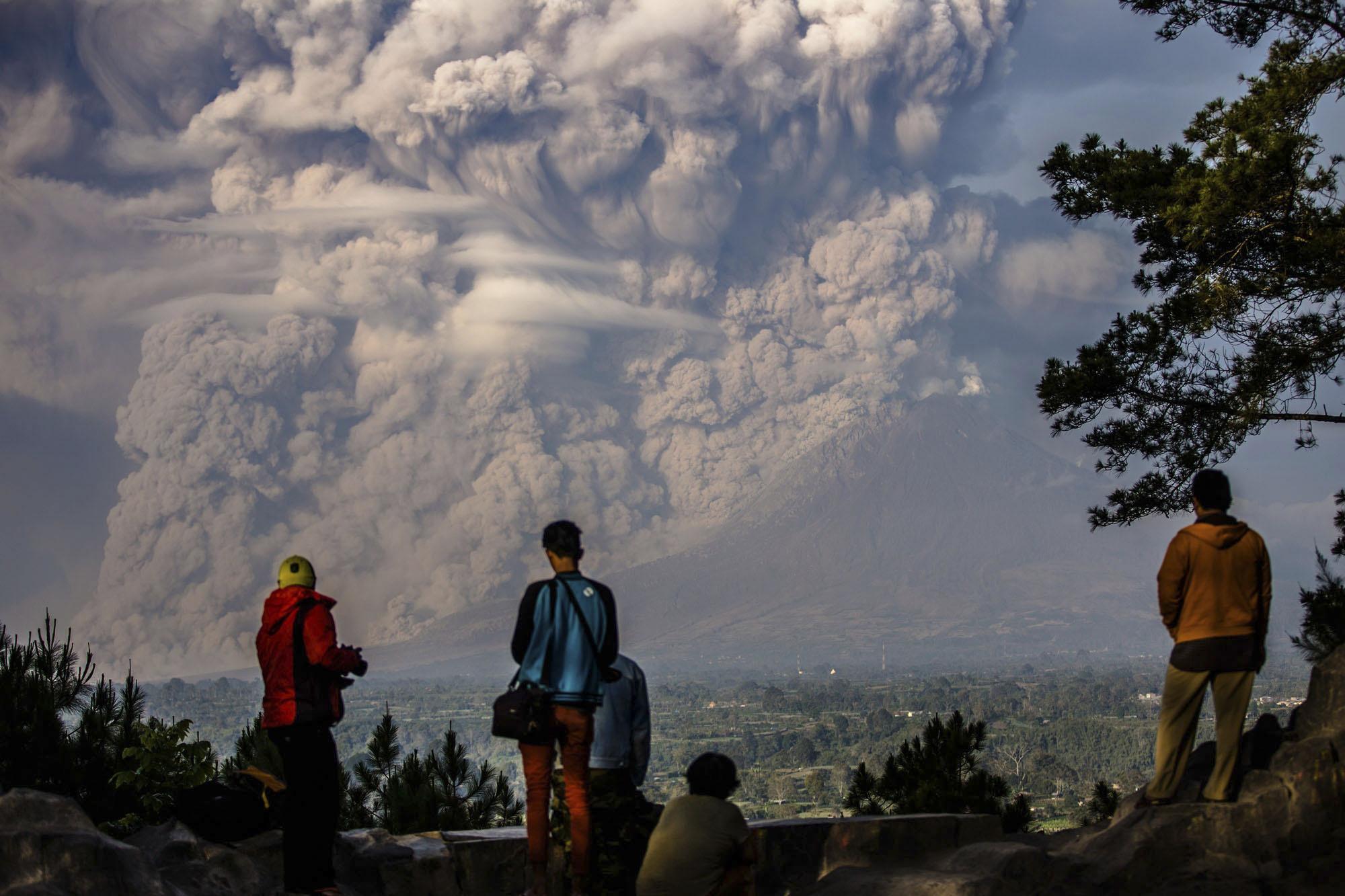 Helybéliek nézik a Sinabung vulkánból áradó hamufelhőt 