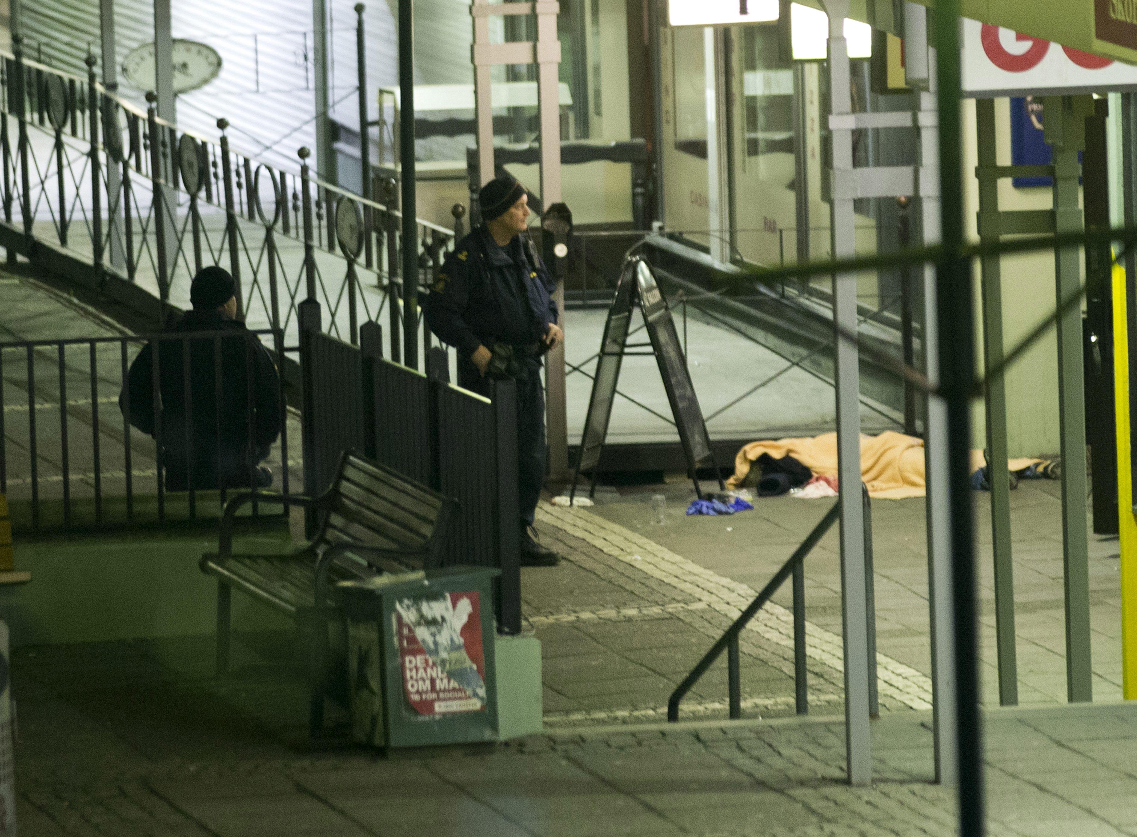 Rendőr áll a lövöldözés egyik áldozata mellett a göteborgi bárnál