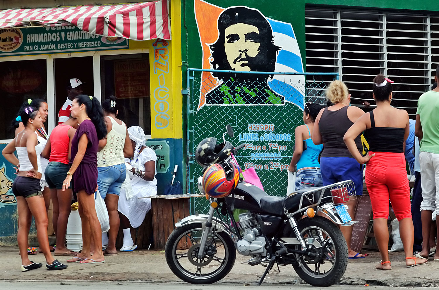 Che Guevara képe alatt várnak élelmiszerre egy havannai piacon