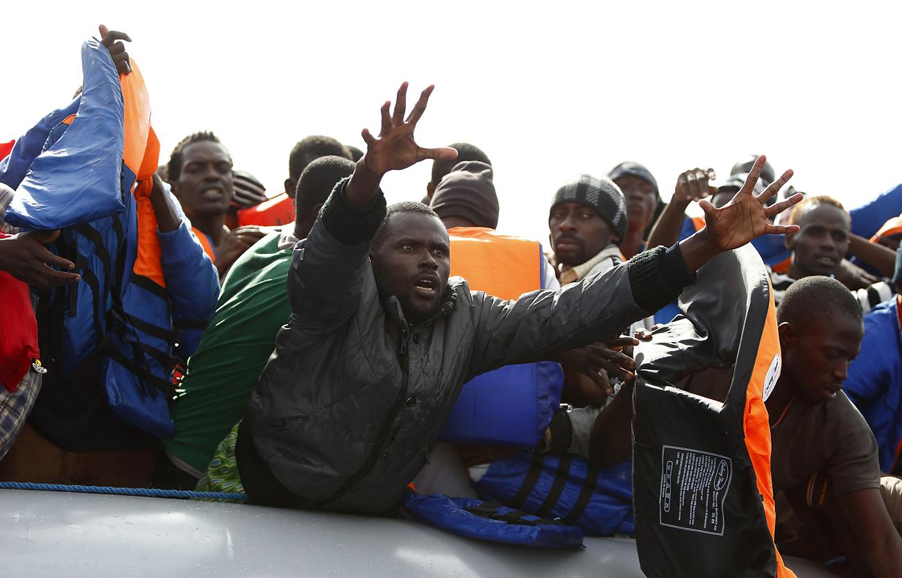 Menekültek Líbia partjainál indulás előtt. Havonta hatmillióval többől