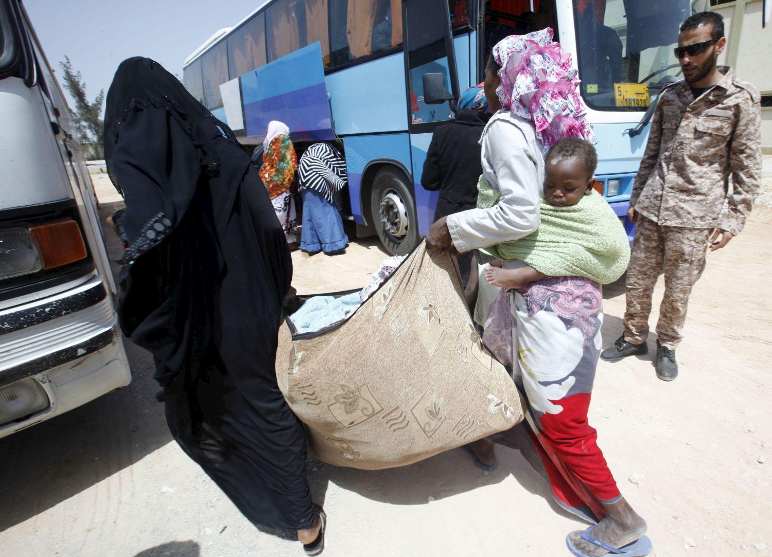 A líbiai Misrata kikötőjében feltartóztatott migránsokat terelnek egy a bevándorlási hivatalba tartó buszra május 9-én