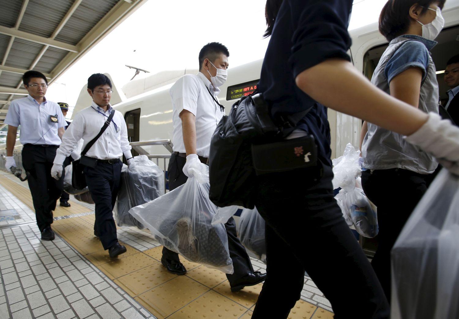 Rendőrök cipelik az utasok poggyászait a tragédia után