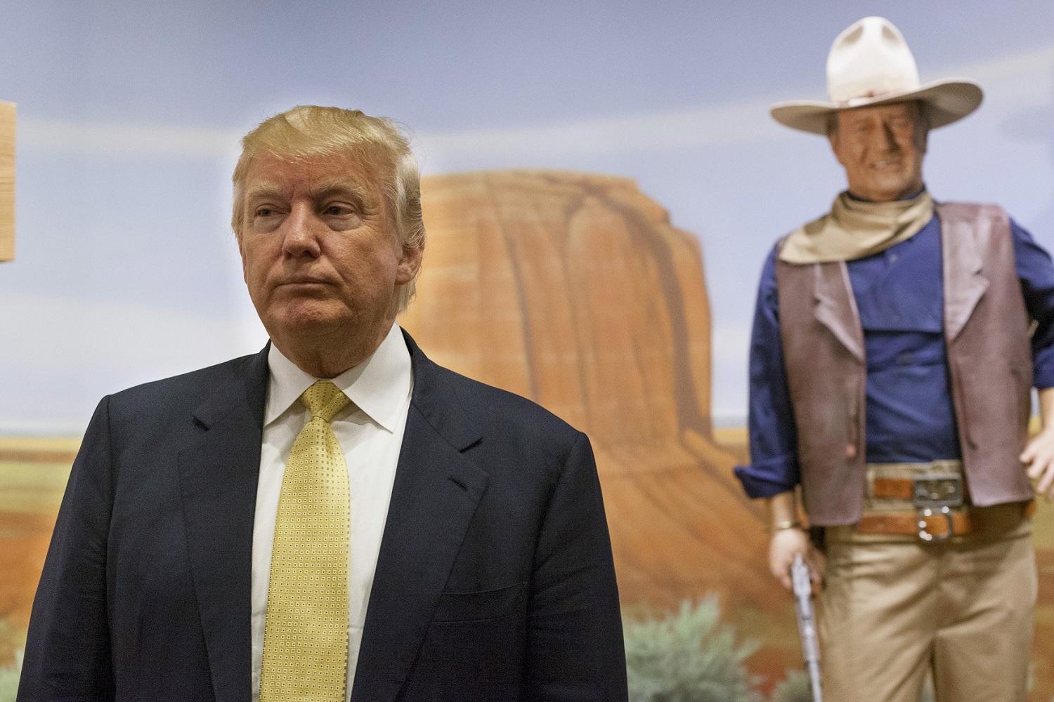 Donald Trump a háttérben John Wayne szobrával. Nem a jó embereket küldik