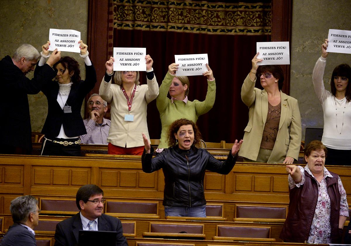 Vadai Ágnes (középen és a DK tilatozó akciója 2013-ban a parlamentben a nőket érő erőszak ellen a vak komondoros kiszólásáról hírhedt fideszes képviselő, Balogh József botránya után