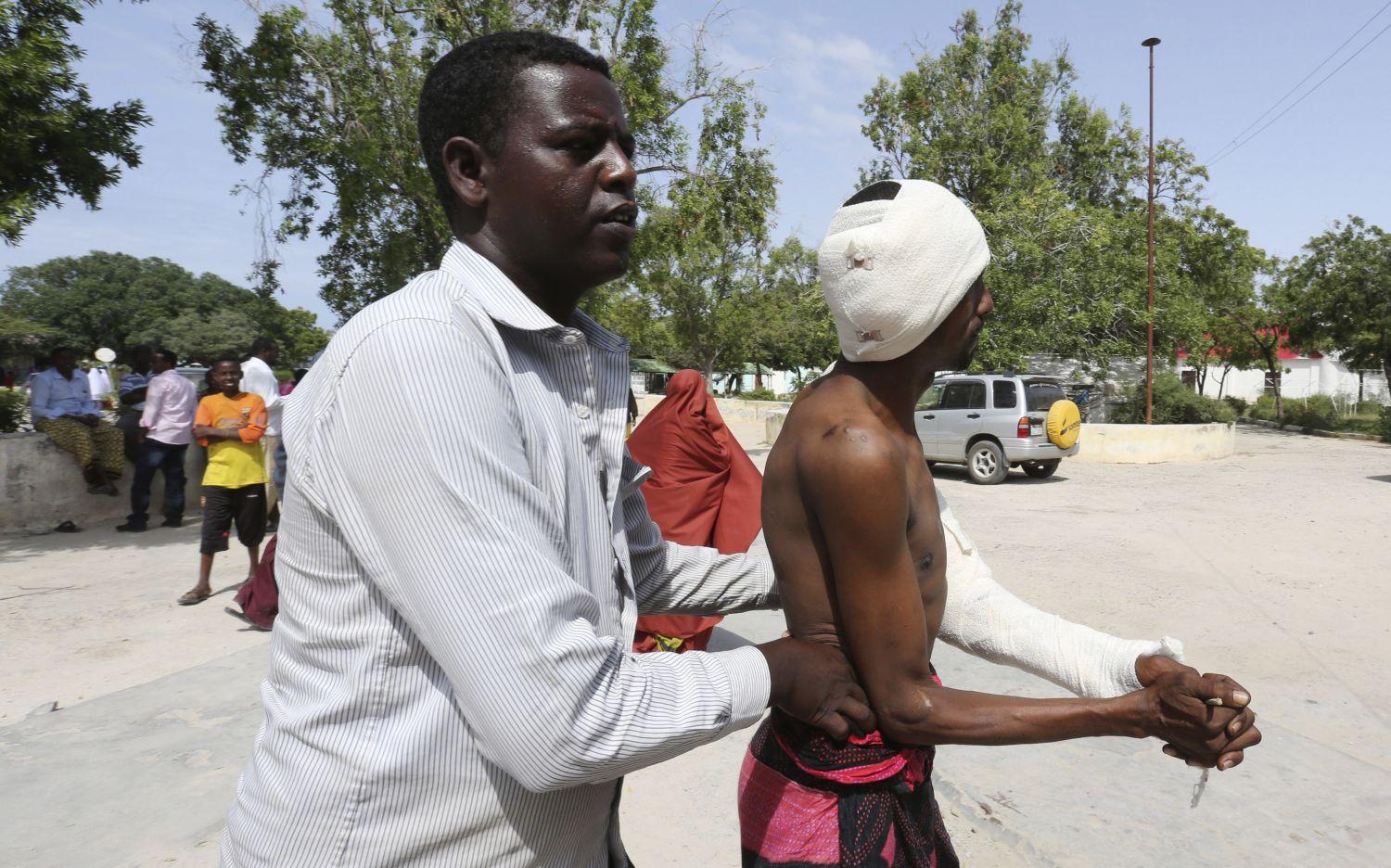 Sebesültet támogat egy civil a mogadishui öngyilkos merénylet után