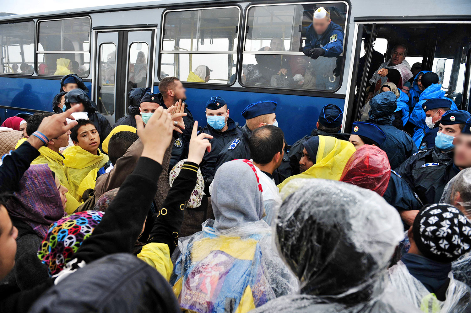 A menekülteket szállító régi Ikarusok egyike. A rendőrök mondják meg, kit és hová vigyenek