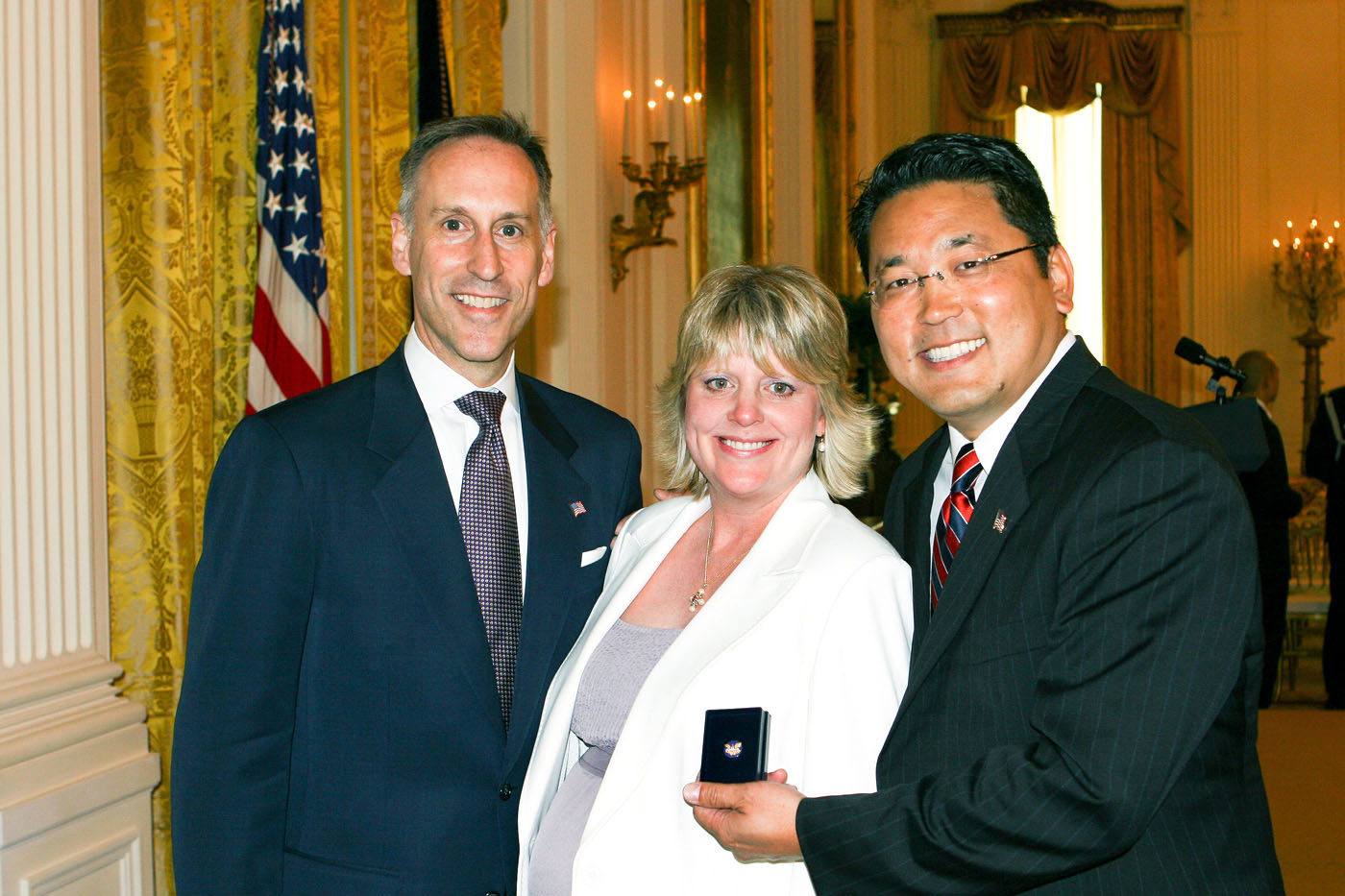 Kay Hiramine feleségével és a USAID állami segélyszervezet egyik vezetőjével, Jack Hawkinsszal a kitüntetés után