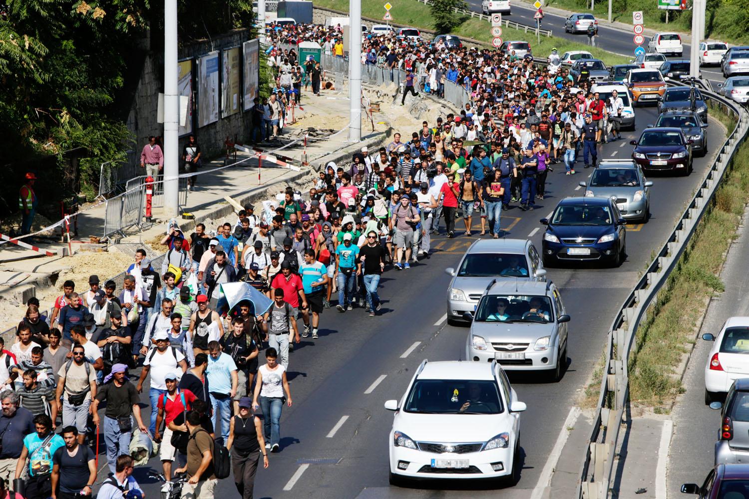 Menekültek vonulnak az autópályán Ausztria felé. Elmegyünk egymás mellett