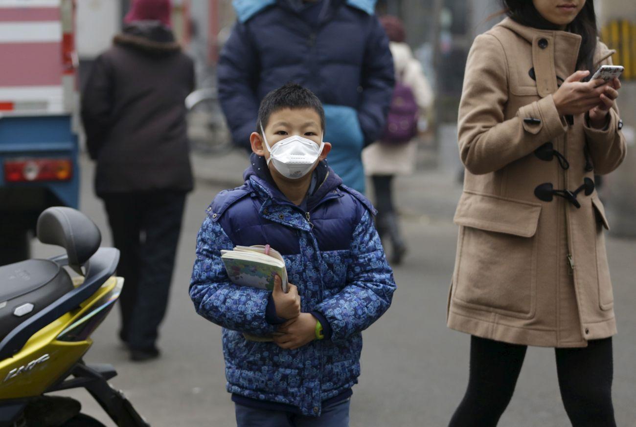 Ez az általános iskolás kisfiú maszkot visel Peking központjában szmog miatt. A vörös riasztás óta az iskolák is zárva vannak.