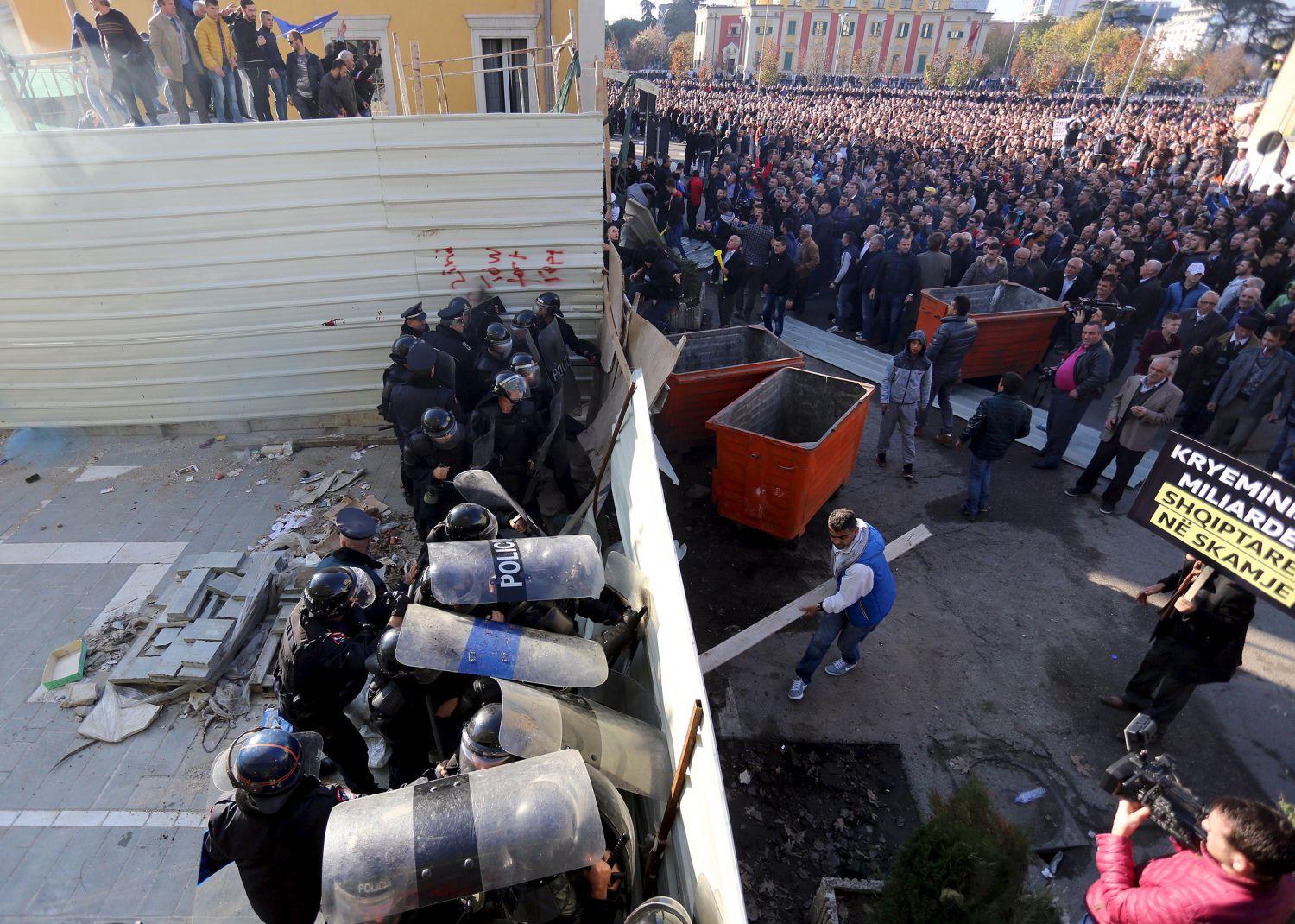 Az ellenzéki Demokratikus Párt szimpatizánsai bontják a Belügyminisztérium épülete előtt felhúzott barikádot Tiranában