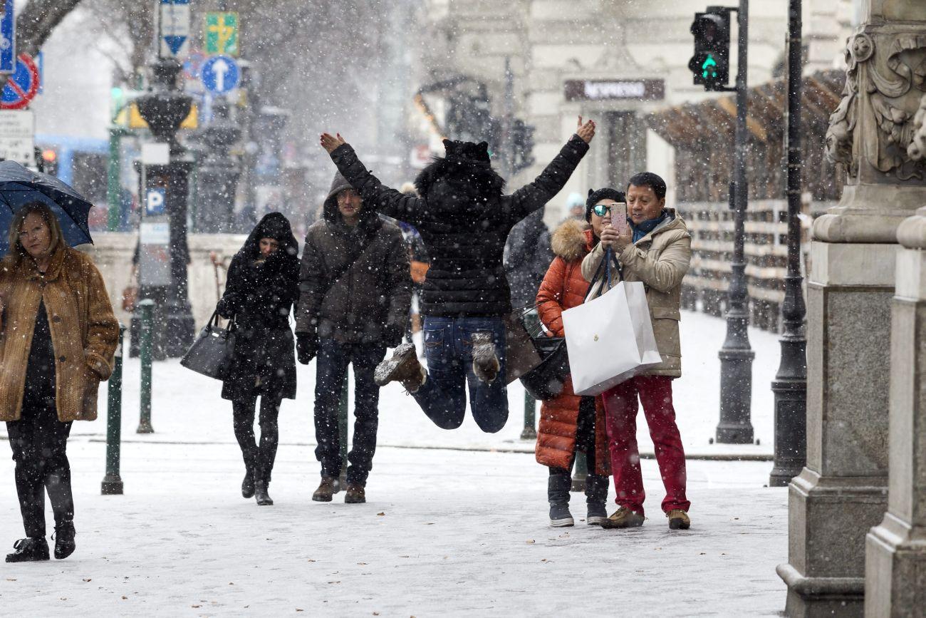 Turisták élvezik a hóesést a fővárosban