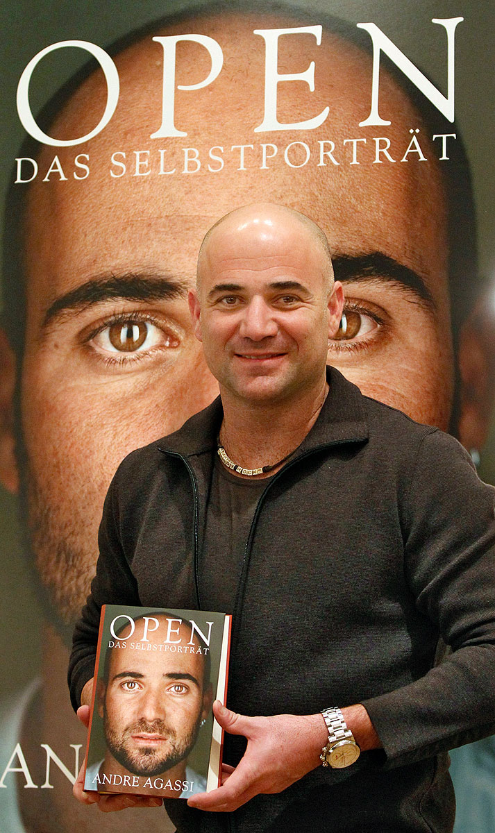 Former tennis player Andre Agassi of the U.S. poses with a copy of his autobiography in Berlin, December 11, 2009.