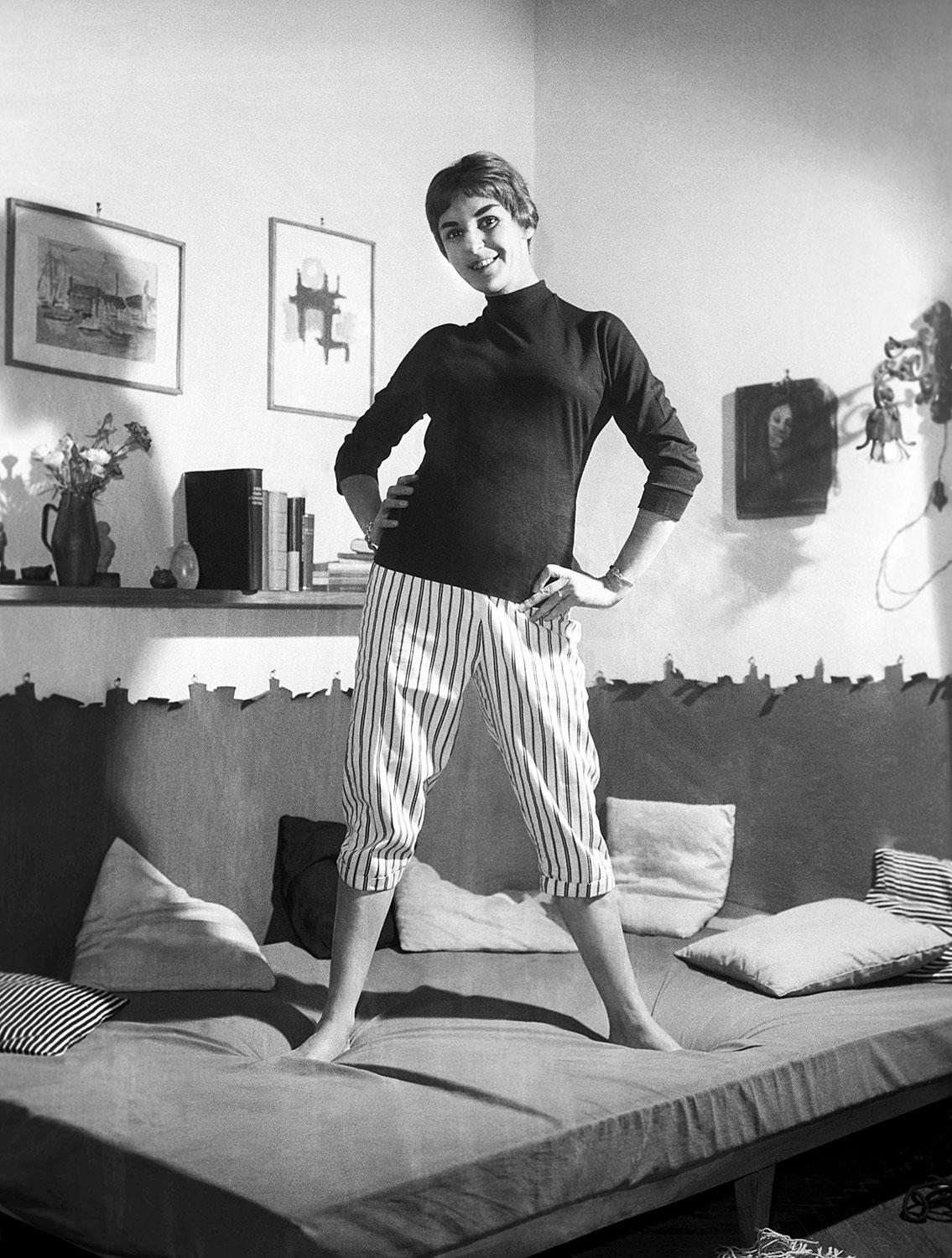 1959: a színésznő otthonában az ágyán állva pózol 