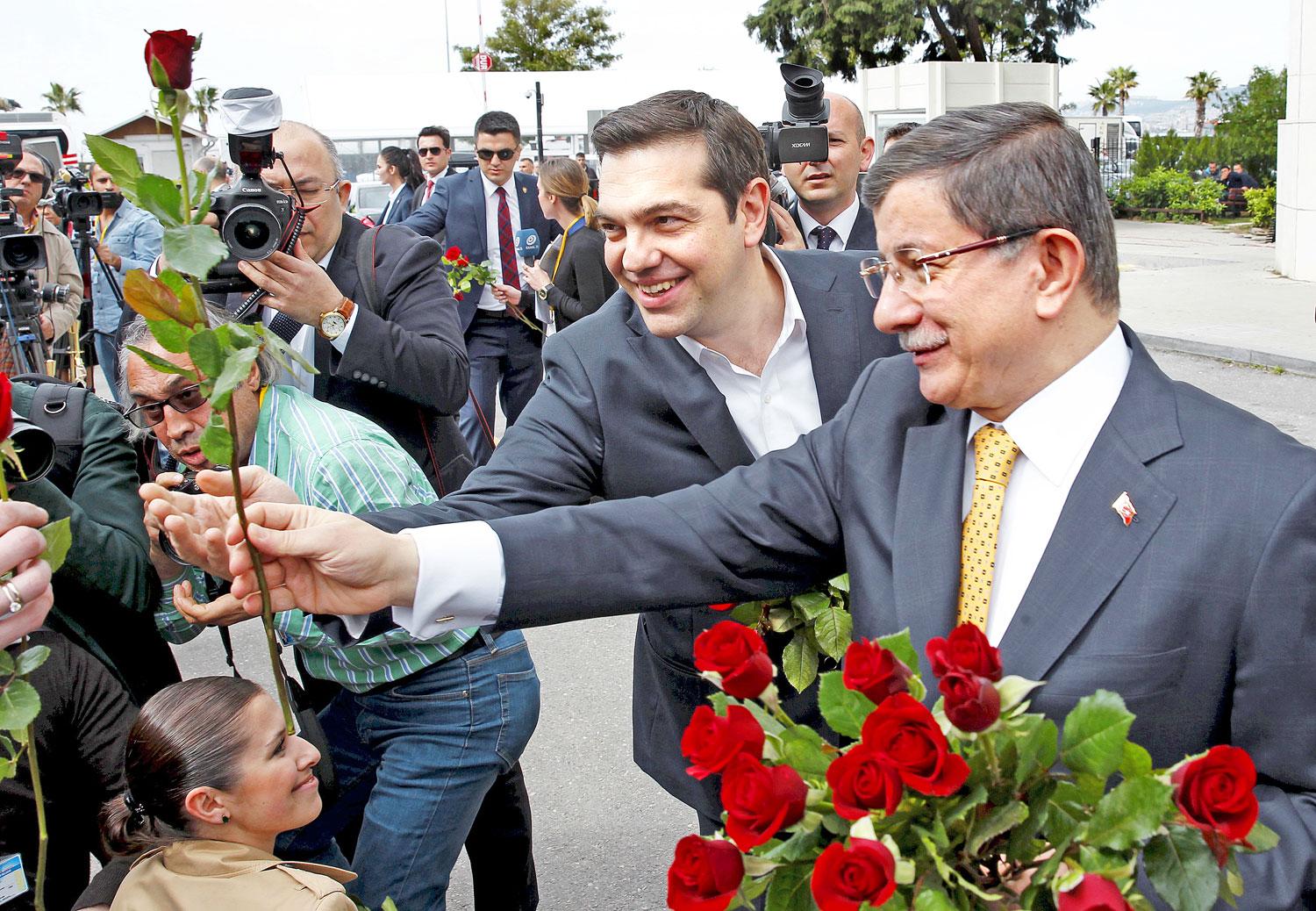 Ciprasz (balra) és Davutoglu virágot oszt az újságírónőknek