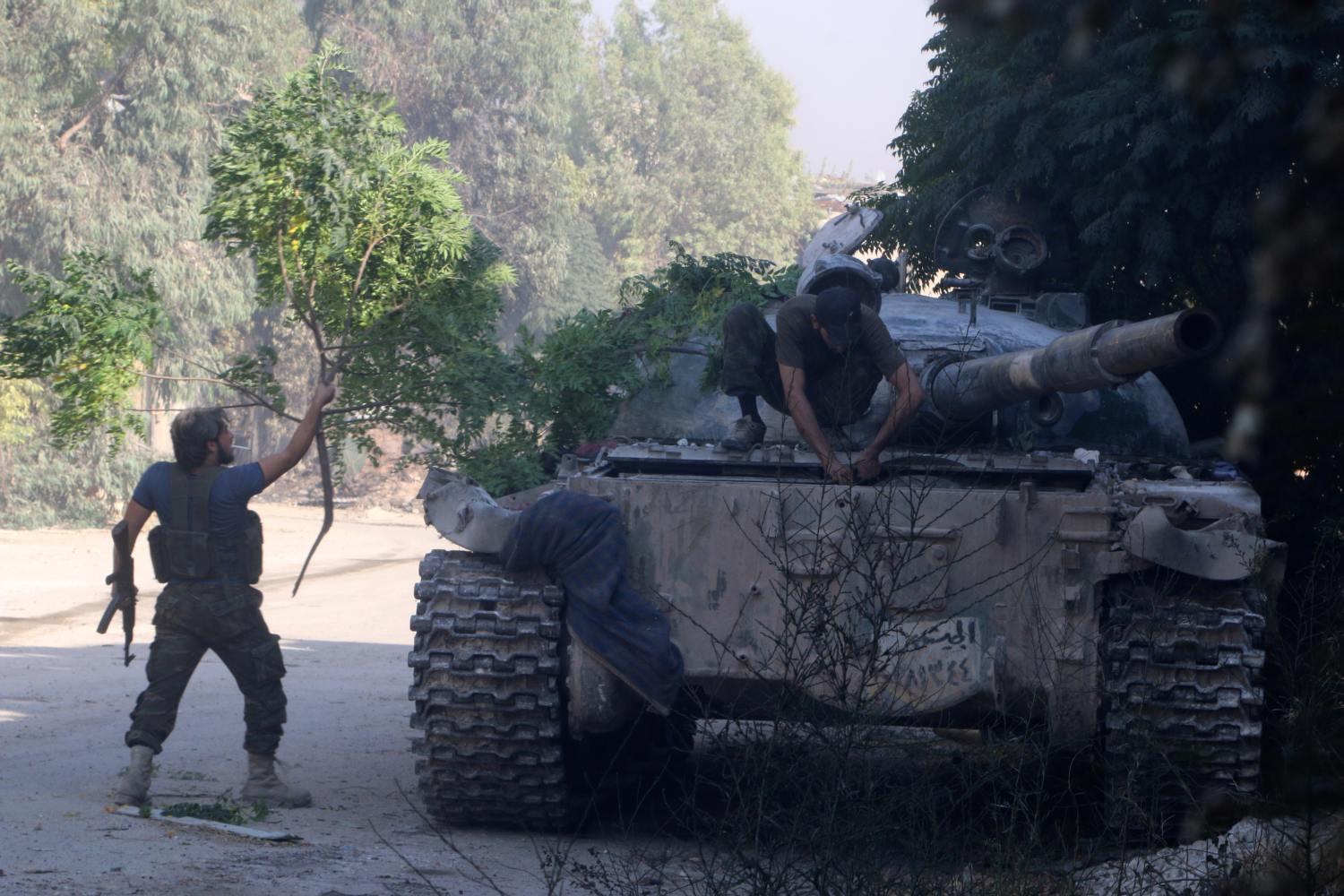 A Szabad Szíriai Hadsereg harcosa egy tankot próbál álcázni Aleppóban