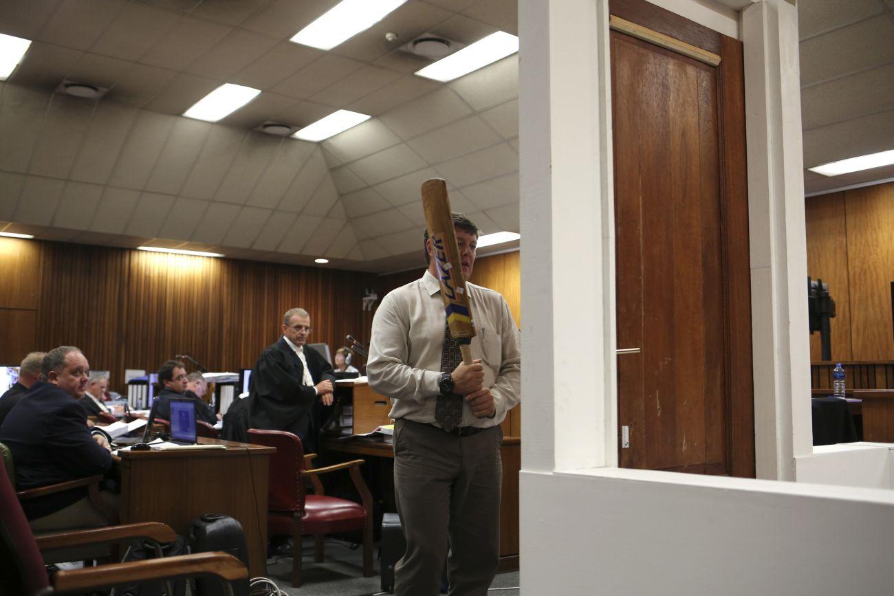 Egy rendőr szemlélteti, hogy törte be Pistorius egy krikettütővel a fürdőszoba ajtaját