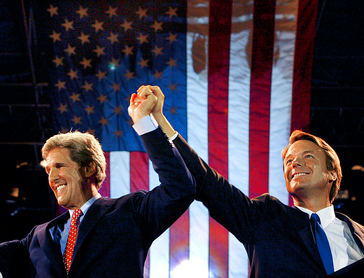 Democratic presidential candidate John Kerry (L) raises the arm of his running mate John Edwards at the Boston Pops concert in Boston, July 30, 2004.  Kerry formally accept the Democratic nomination for president at the party's convention.   REUTERS/