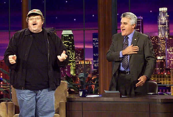 Michael Moore fellép Jay Leno híres tévés talkshow-jában. Éppen az Amerika, te csodálatos kezdetû hazafias dalt éneklik