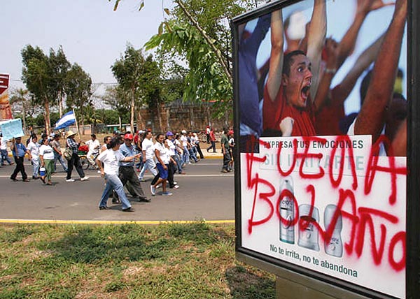 Ki Bolanóval!!! - graffiti az elõtérben, a háttérben tüntetõk vonulnak az elnöki palota felé