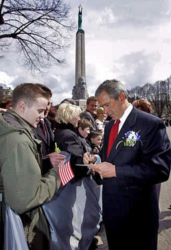 Bush autogramot oszt a rigai Szabadság emlékmû elõtt