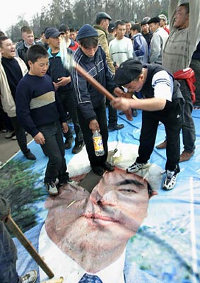 Ellenzéki tüntetõk a jelenlegi elnök portréját törik össze Osban