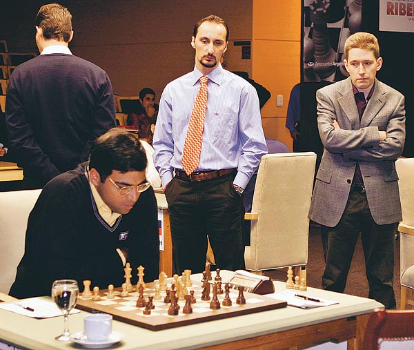 Topalov (középen) és Adams Anandnak kibicel, Lékó (háttal) meg "másutt jár", amíg az indiai lép