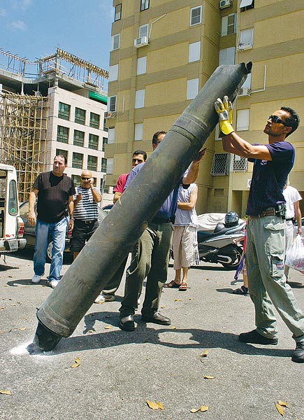 Izraeli bombaszakértõ egy Haifában becsapódott Hezbollah-rakétát vizsgál  