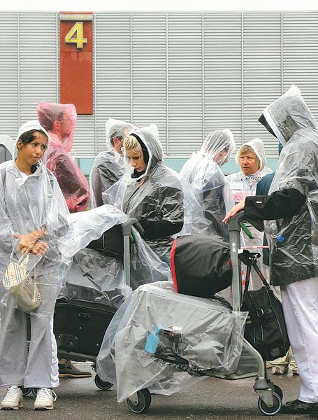 A Heathrow-i repülõtér épületén kívül állnak sorba a csomagellenõrzésre váró utasok   