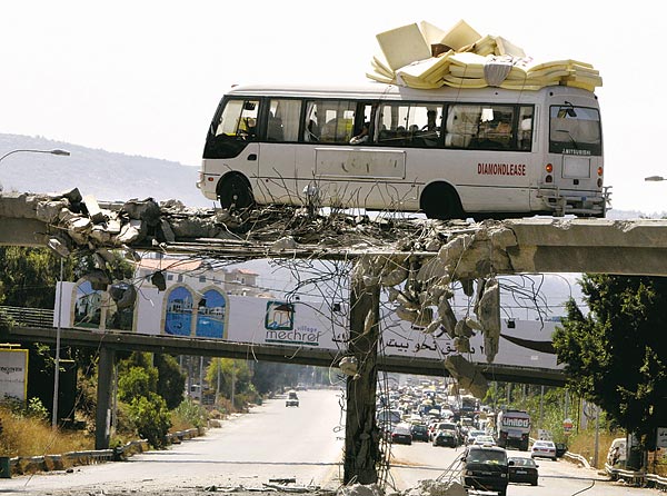 Több ezer menekült tér haza Dél-Libanonba. Ez a busz egy sérült hídon halad át   