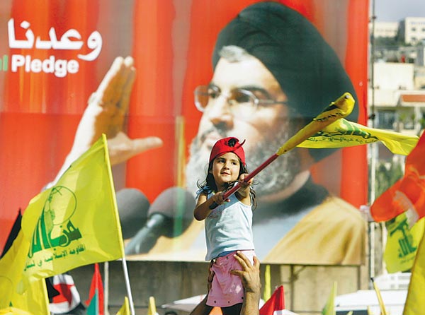 Kislány lengeti a Hezbollah-zászlót a vezér képmása elõtt Bejrútban  