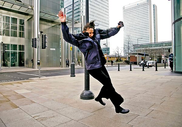 Londoni járókelõt sodor el az orkánerejû szél a brit fõváros üzleti negyedében, Canary Wharfban