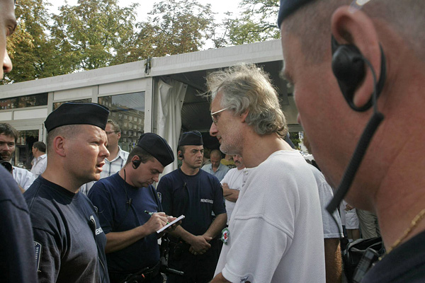 Gonda Lászlót, a Magyar Nemzeti Bizottság 2006 ügyvivőjét rendőrök veszik körül a Liberálisok Háza előtt, mialatt Kóka János mondott ünnepi beszédet