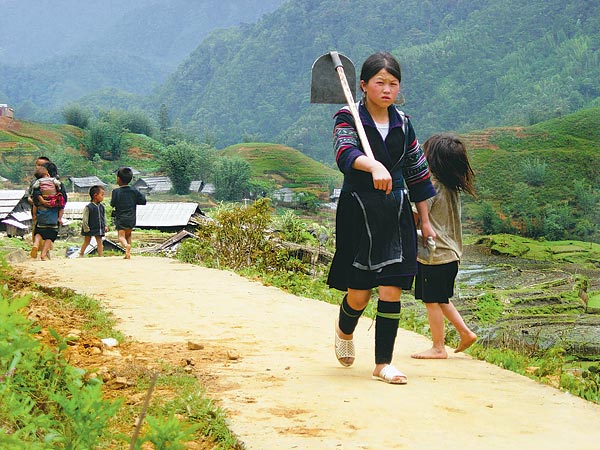 Hmong lány indul dolgozni a rizsföldre Sapa környékén