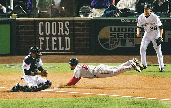 Mike Lowell (Boston, középen) akciója a döntő negyedik mérkőzésén. Mindent bedobtak