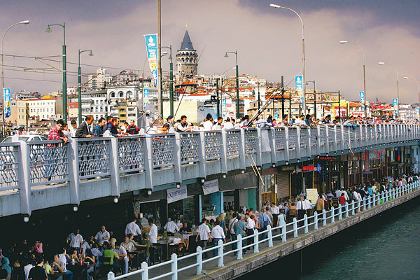 Az Aranyszarv-öböl feletti emeletes hídon horgásznak és ebédelnek az isztambuliak, a háttérben az európai negyed