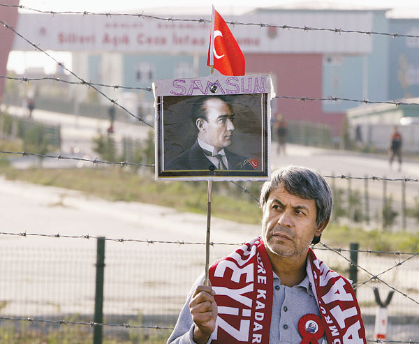 A Silivri börtön előtt áll egy tüntető Kemal Atatürk portréjával. Az ő nevében