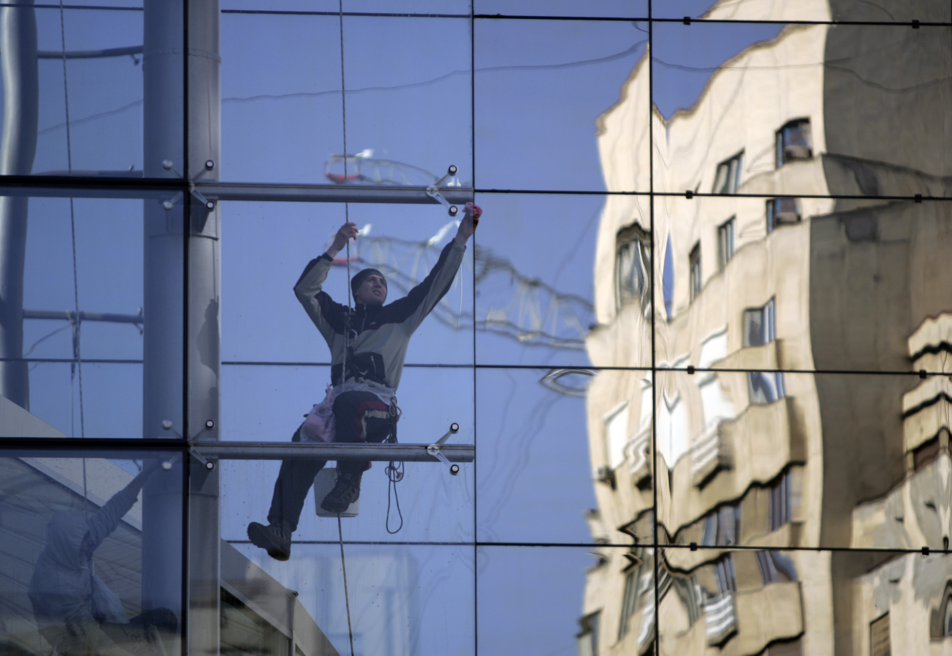 Bukaresti hotel ablakát tisztító munkás