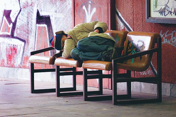 Hajléktalan a Flórián téri aluljáróban. A fekvésellenesre formált padon is lehet aludni