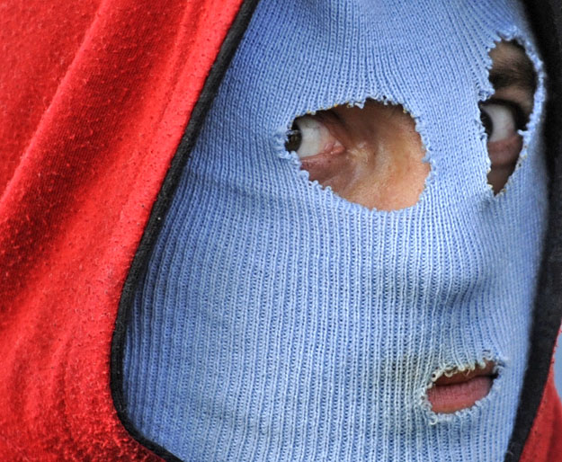 A Roma resident of the Janov quarter wears a mask in front of his house in Litvinov November 17, 2008. About 500 ultra-right wing protesters clashed with police after they tried to reach a Roma settlement during their demonstration against 