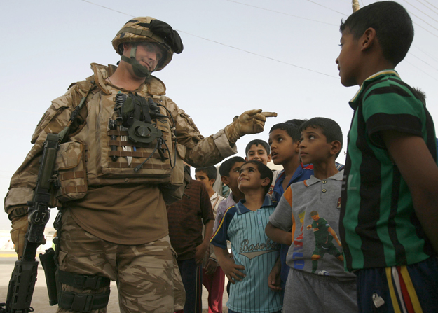 Brit katona gyerekekkel beszélget Garma város piacán, Irakban