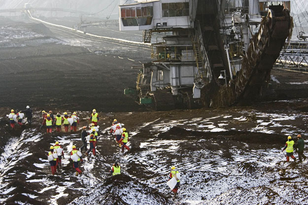 Greenpeace activists walk towards an excavator at Jozwin-2B, a lignite and brown coal mine, owned by state company KWB, in Konin, western Poland November 24, 2008. The demonstrators attempted to paint a 