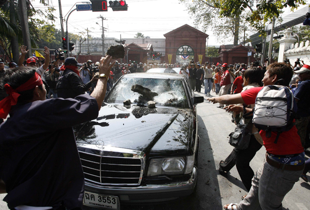 Bangkoki tüntetők kövekkel dobálják a parlamenti képviselők autóját 