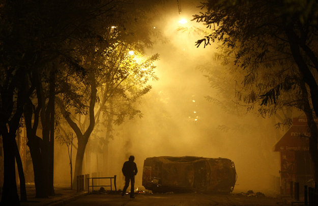 Tüntető és felgyújtott autó Athén külvárosában 