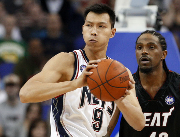 New Jersey Nets' Yi Jianlian (L) looks to pass over Miami Heat's Udonis Haslem during the first quarter of their NBA pre-season basketball game in London October 12, 2008. REUTERS/Suzanne Plunkett (BRITAIN)