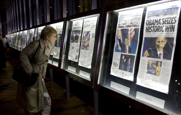 A woman views the front pages of Wednesday's newspapers from around the world on display outside the Newseum in Washington November 5, 2008. Americans woke with joy, cautious optimism and frank worry on Wednesday after the historic win by Democrat Ba