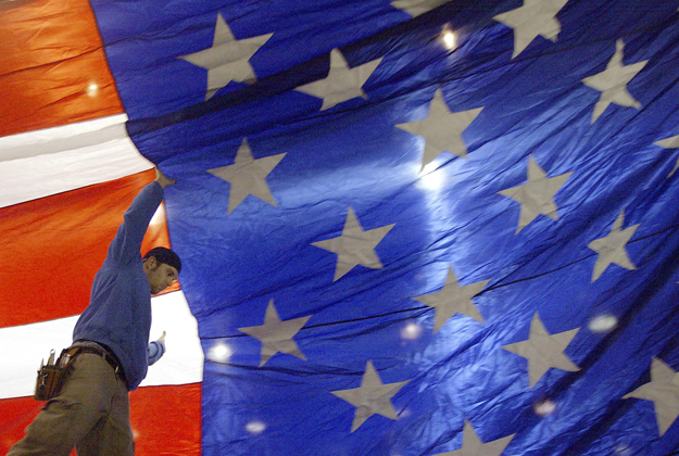 Sky Cleven sets up a flag at election night headquarters for U.S. Democratic presidential candidate Senator John Kerry (D-MA) in Madison, Wisconsin February 17, 2004. Kerry is one of several candidates campaigning in the state's primary.     REUTERS/