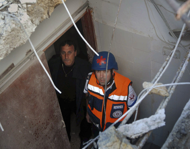Naharíja, 2009. január 8.
Izraeliek egy mennyezeten ütött lyukat néznek meg Naharíjában 2009. január 8-án, miután Libanonból rakétatámadás érte az észak-izraeli várost és környékét. Az iraeli rádió szerint két ember megsebesült. Izrael december 27. 