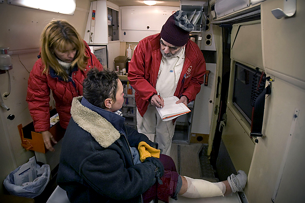 Eöry Ajándok háziorvos (j) egy hajléktalant lát el a Magyar Máltai Szeretetszolgálat által rendelőként működtetett mentőautóban a Móricz Zsigmond körtéren, január 9-én éjjel.