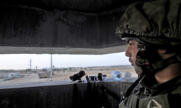 An Israeli soldier stands in an observation post near the border with the northern Gaza Strip January 12, 2009. Israeli leaders trying to find a knockout blow against Hamas militants defying a 17-day-old assault on the Gaza Strip have sent army reser