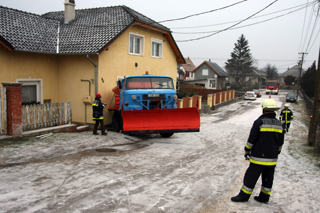 Tûzoltók dolgoznak a Székesfehérváron a Lugosi utcában, ahol egy hókotró autó lakóház oldalába csapódott.